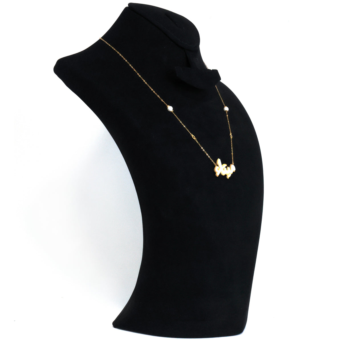 Gold necklace with a pendant on a black mannequin bust against a white background