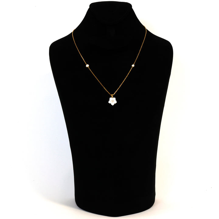 Gold necklace with a heart pendant on a black mannequin bust against a white background