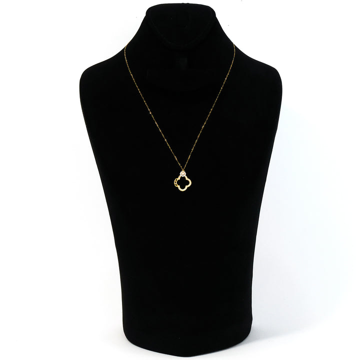 Gold necklace with a clover pendant on a black mannequin bust against a white background