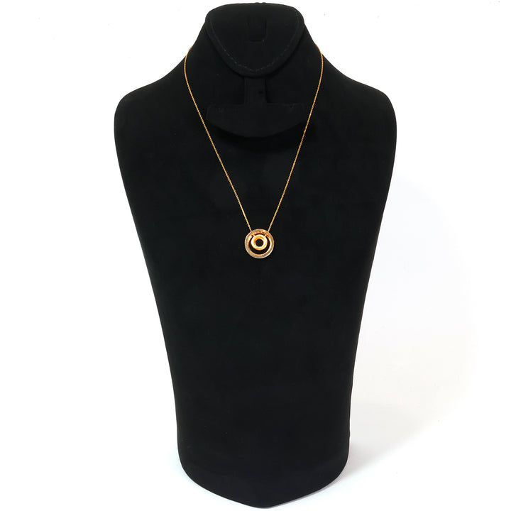 Gold necklace on a black mannequin bust against a white background