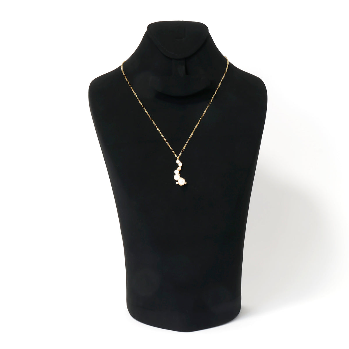 Black mannequin wearing a gold necklace with a pendant on a white background