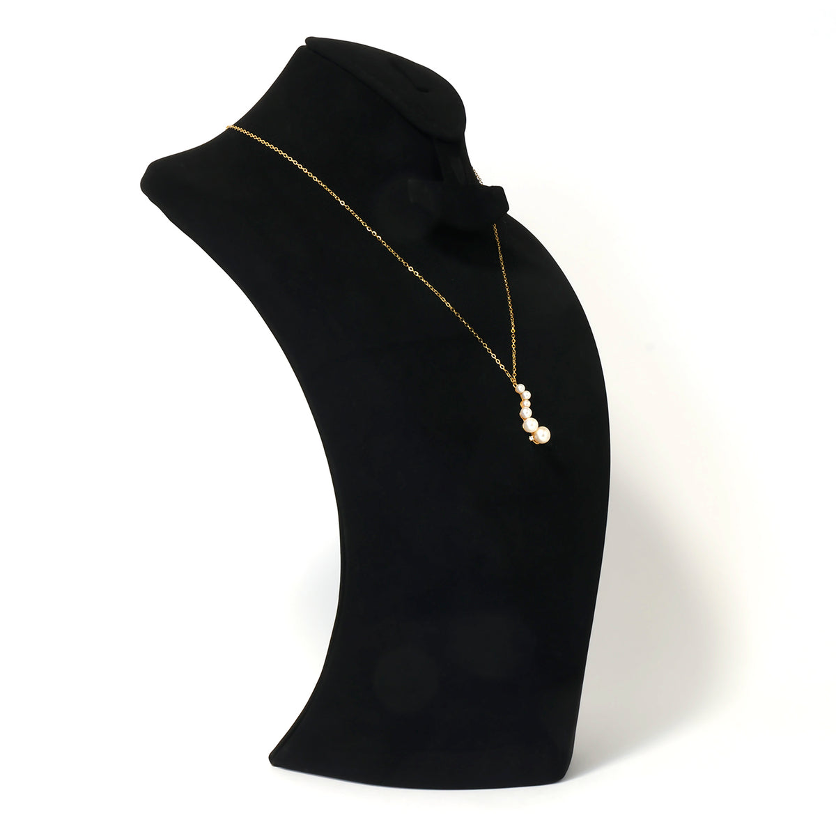Gold necklace with pearls on a black mannequin bust against a white background