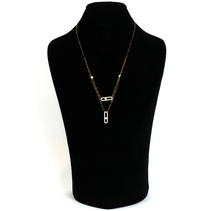 Gold necklace on a black mannequin bust against a white background