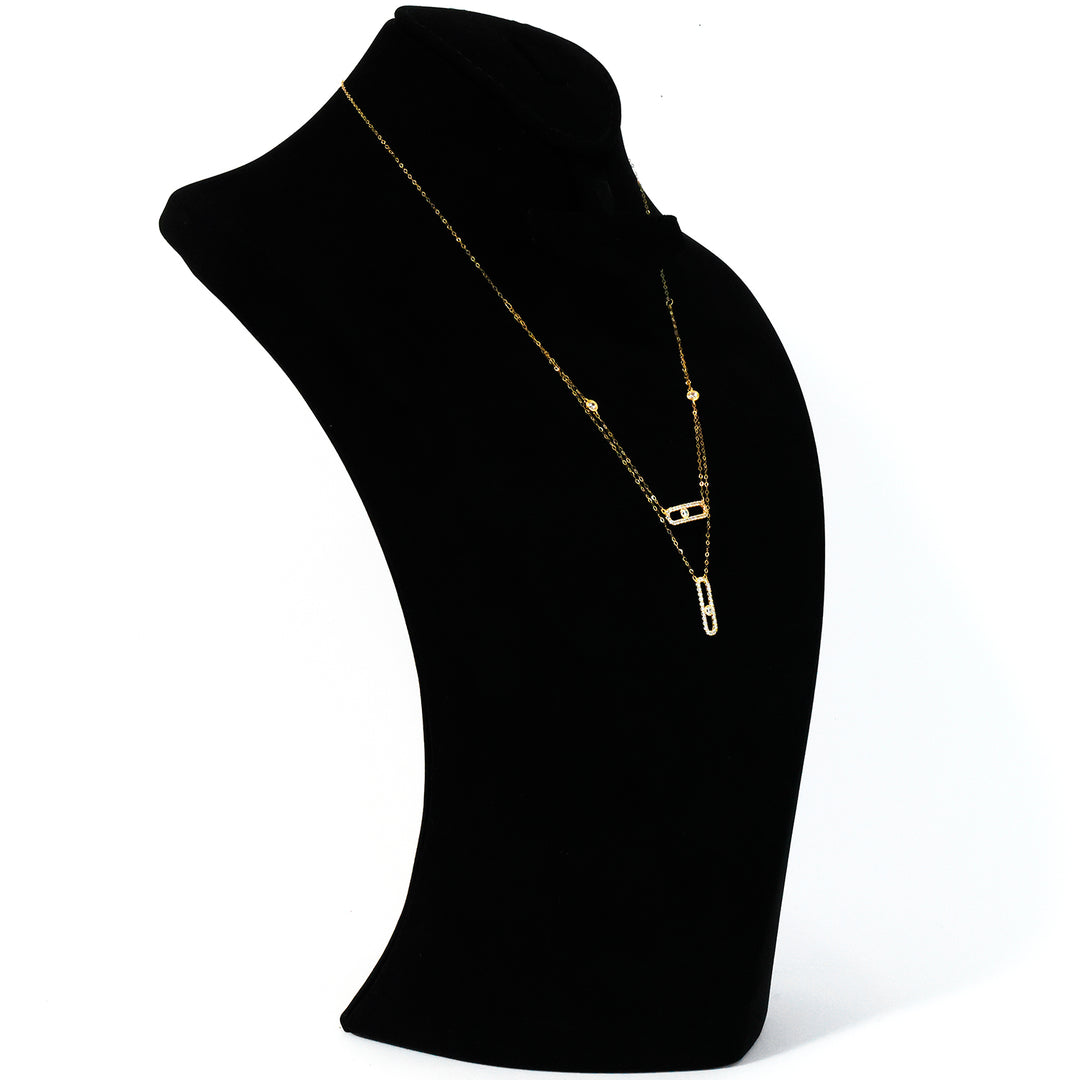 Gold necklace on a black mannequin bust against a white background