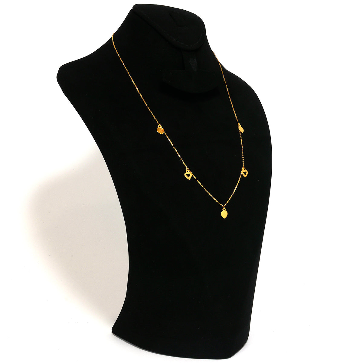 Gold necklace on a black mannequin bust with a white background