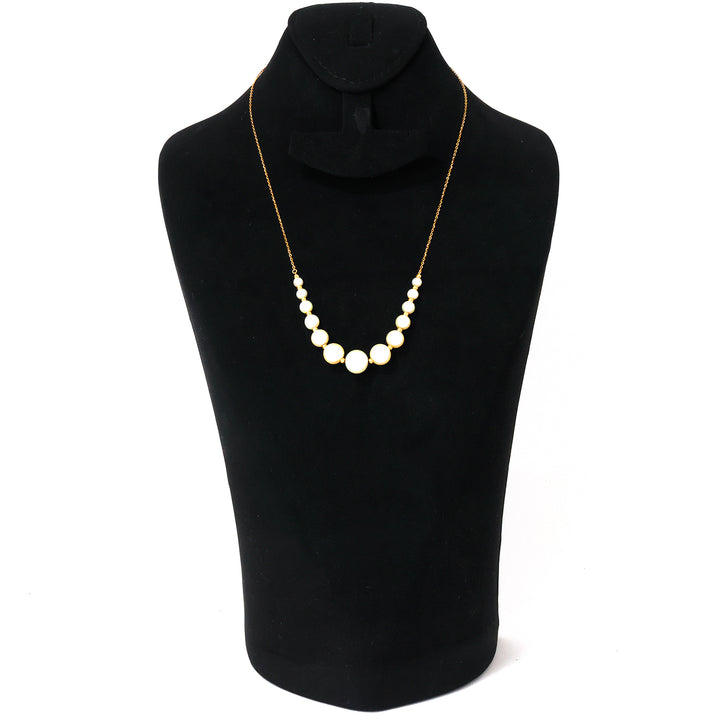 Pearl necklace on a black mannequin with a white background