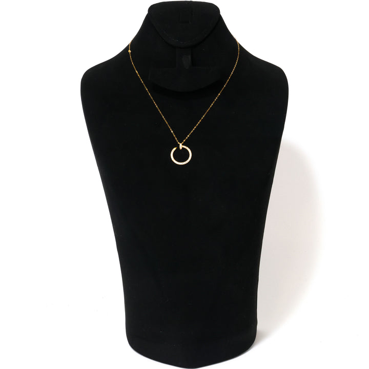 Gold necklace with a circular pendant on a black mannequin bust.