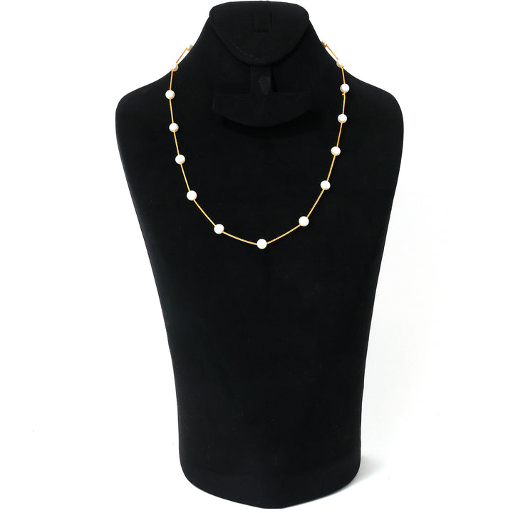 Necklace with white beads on a black mannequin bust against a white background