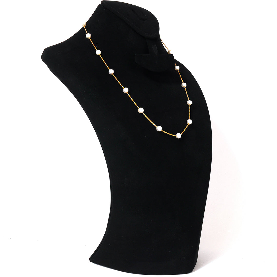 Pearl necklace on a black mannequin bust against a white background