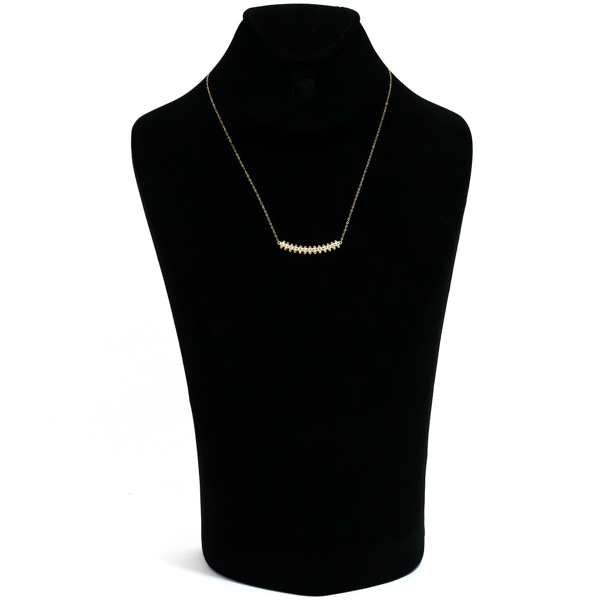 Gold necklace on a black mannequin bust with a white background