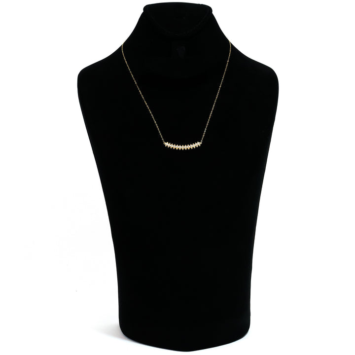Gold necklace on a black mannequin bust with a white background