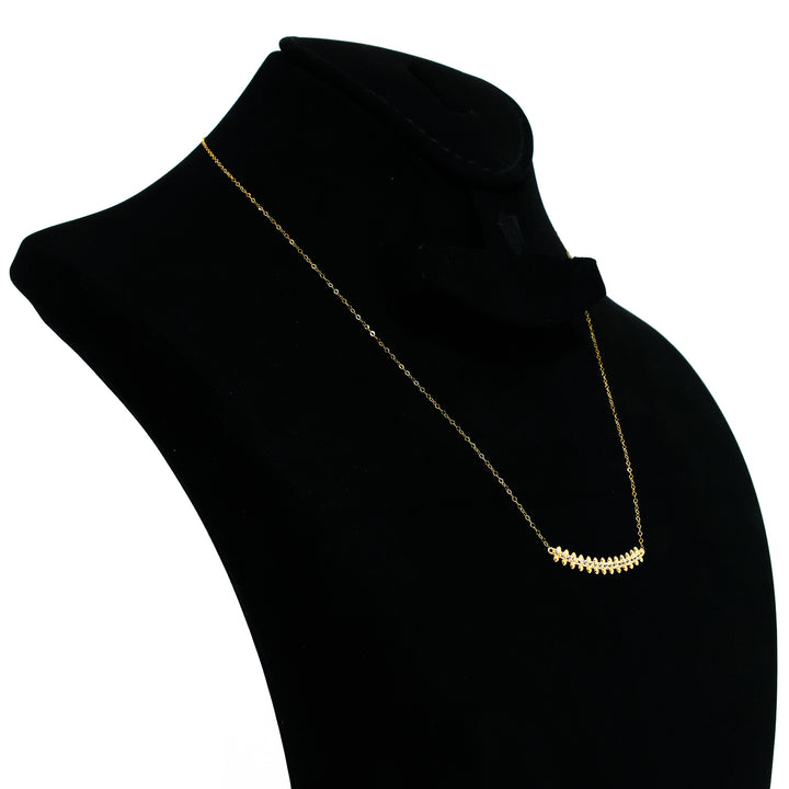Gold necklace on a black mannequin with a white background