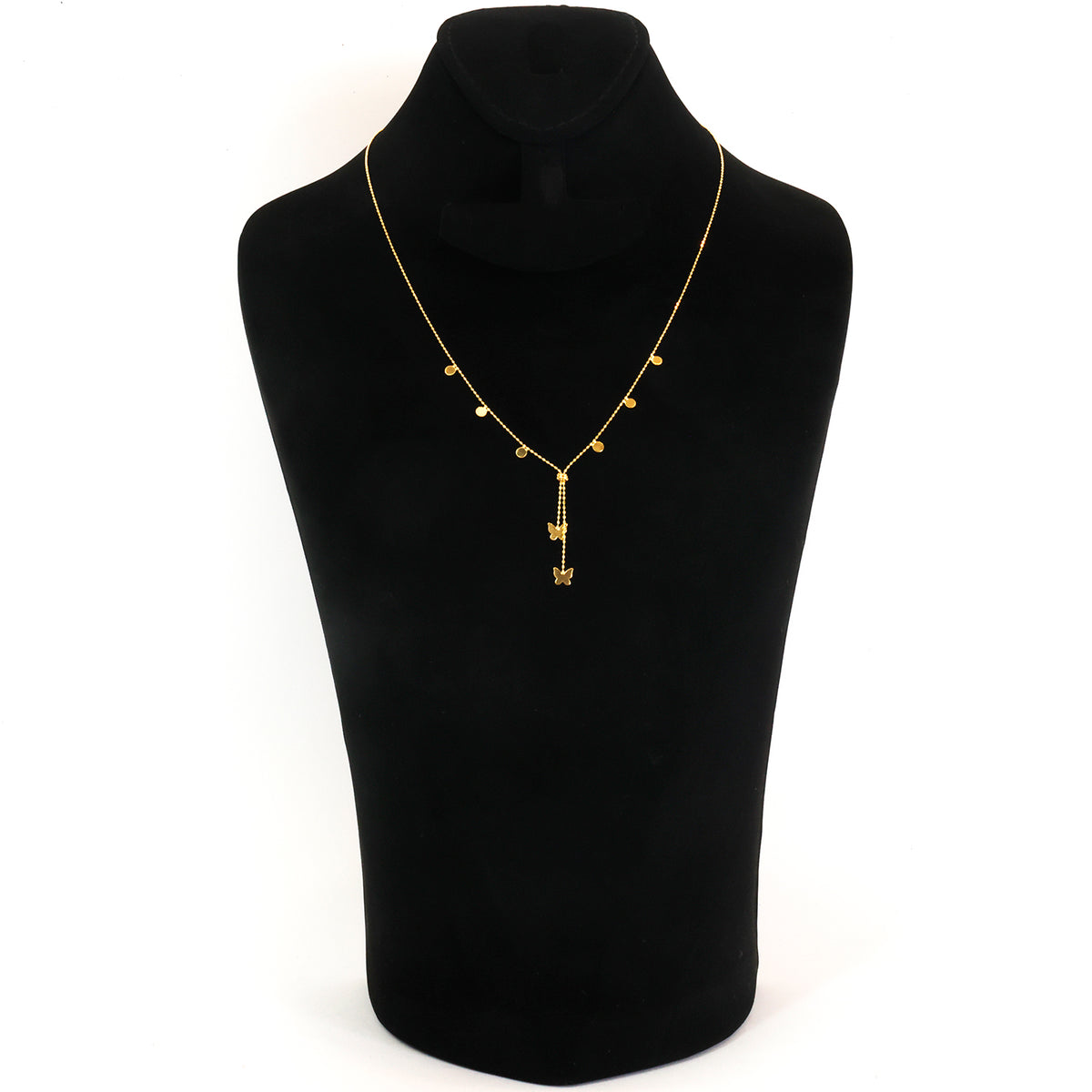 A delicate gold necklace displayed on a black jewelry bust against a white background. The necklace features a fine chain with small gold beads and a central pendant with a vertical bar and a small hanging charm.