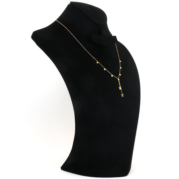 Gold necklace with a pendant on a black mannequin bust against a white background