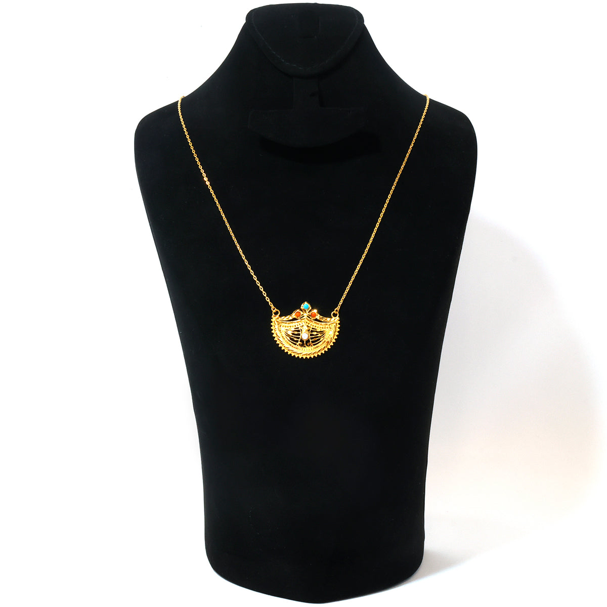 A gold pendant necklace displayed on a black jewelry bust against a white background. The pendant features a central gold figure with small red and orange details, surrounded by a textured gold border.