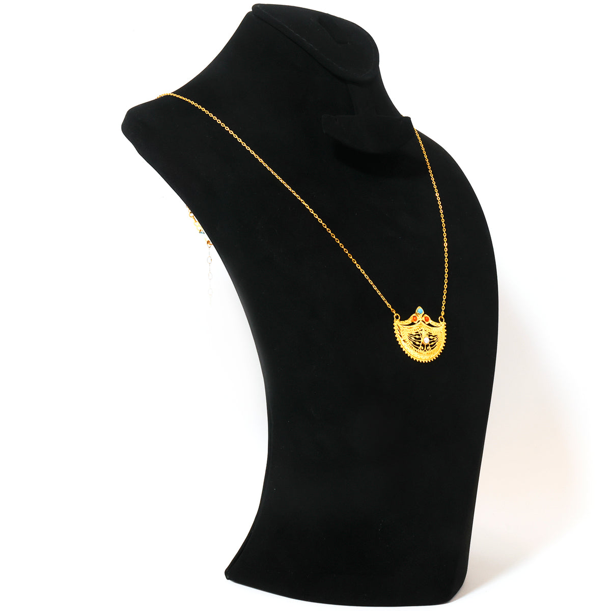 A gold pendant necklace displayed on a black jewelry bust against a white background. The pendant features a shield-like design with a central emblem.