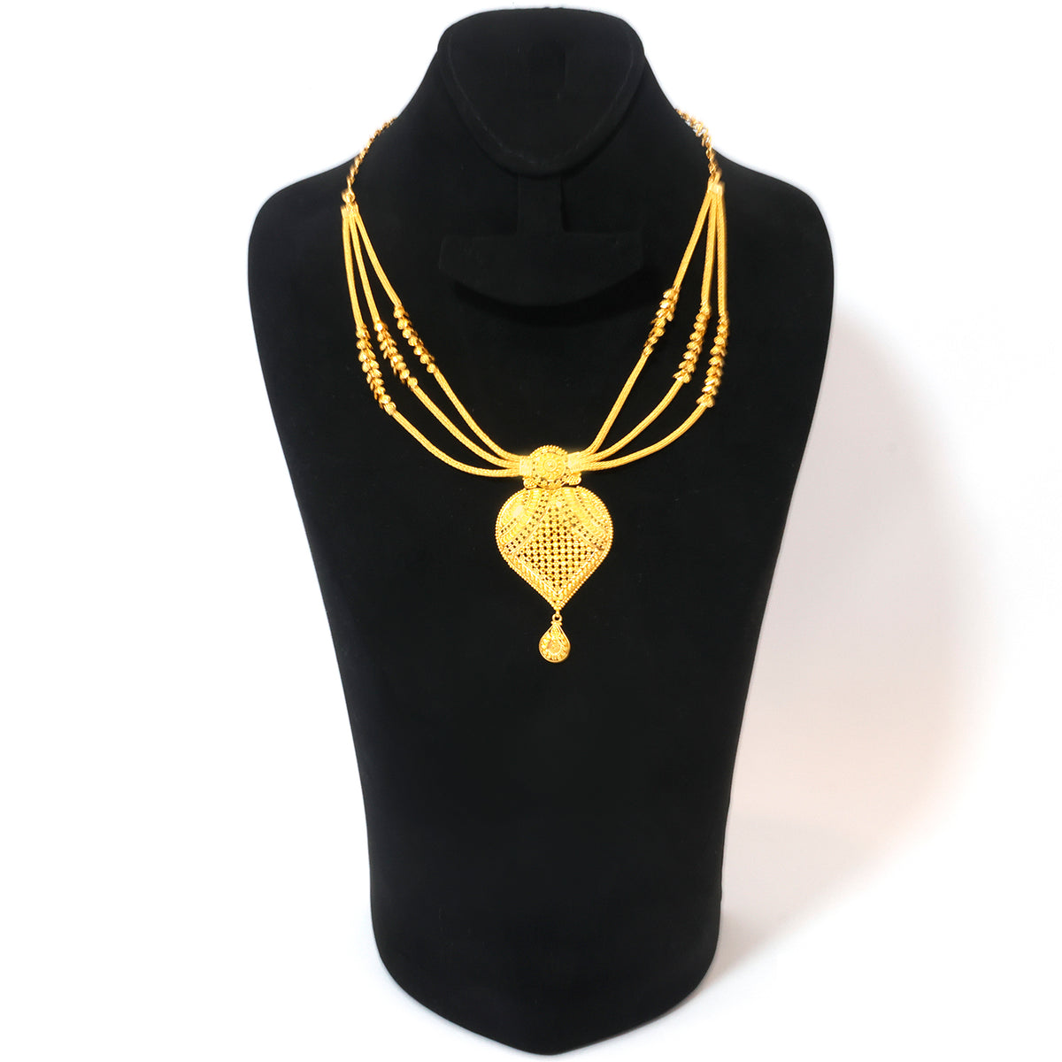 A gold multi-strand necklace with a large heart-shaped pendant and small bead accents, displayed on a black jewelry bust against a white background.