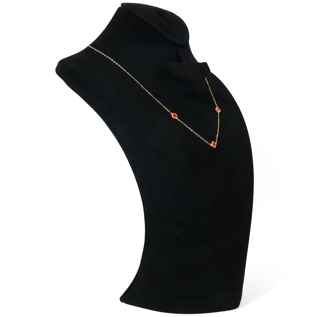 A delicate gold chain necklace with three small red diamond-shaped beads, displayed on a black velvet jewelry bust against a white background.