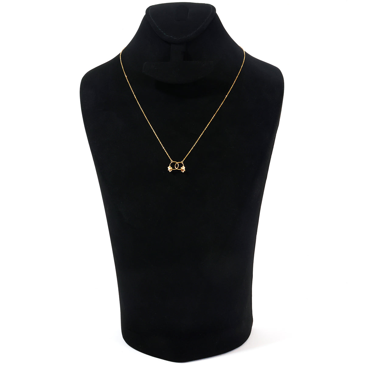 A delicate gold necklace with a small interlocking double-O pendant, displayed on a black velvet jewelry bust against a white background.