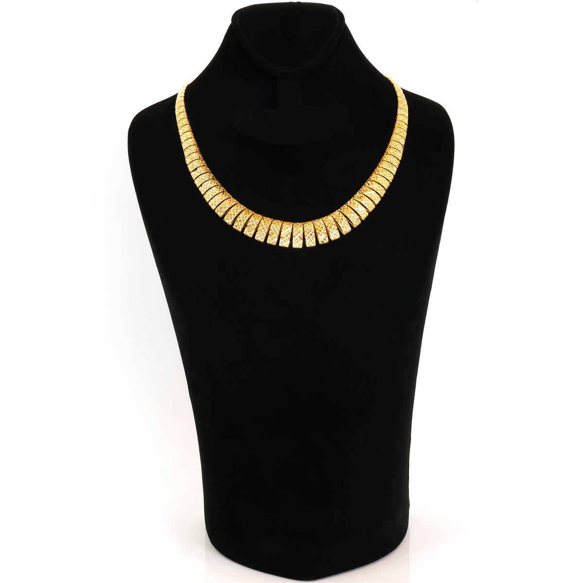 A wide, chunky gold collar necklace displayed on a black velvet jewelry bust against a plain white background.