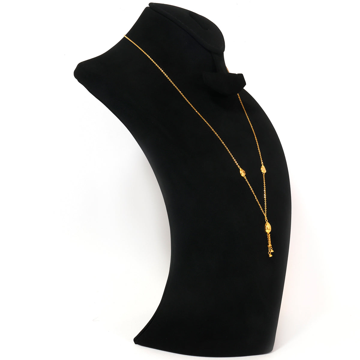 A delicate gold chain necklace with small bead details and a dangling charm, displayed on a black neck bust against a white background.