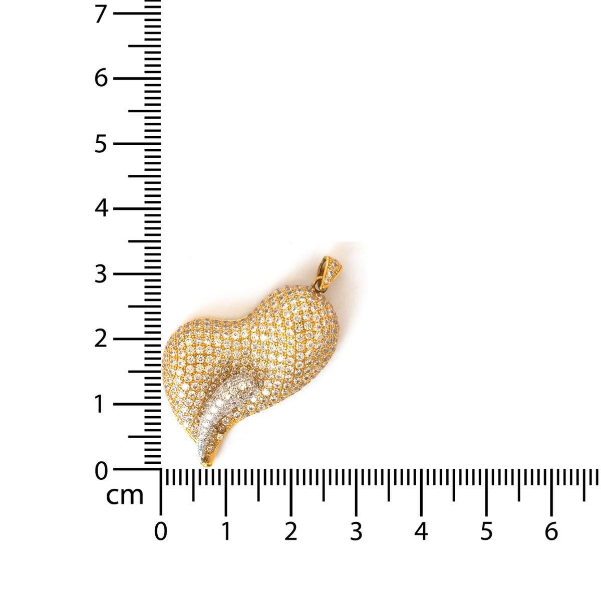 Gold heart-shaped pendant with clear stones next to a ruler for scale on a white background