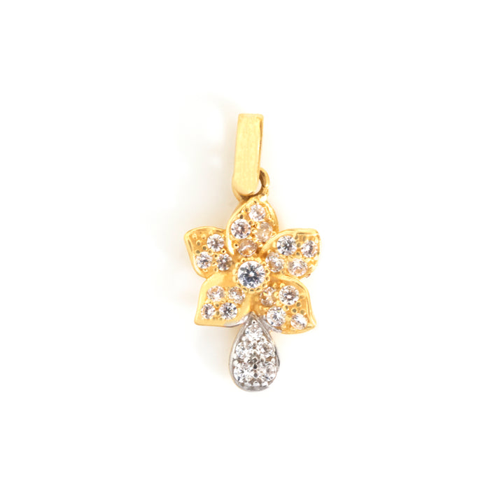 A gold flower-shaped pendant adorned with clear pavé stones, featuring a teardrop-shaped clear stone hanging below, set against a plain white background.