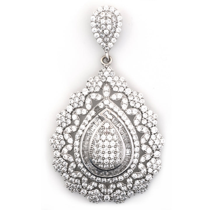 A teardrop-shaped silver pendant adorned with numerous clear pavé gemstones, featuring a detailed floral and geometric pattern, set against a plain white background.