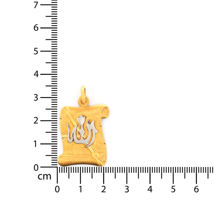 Gold pendant with a central design on a white background with a ruler for scale.