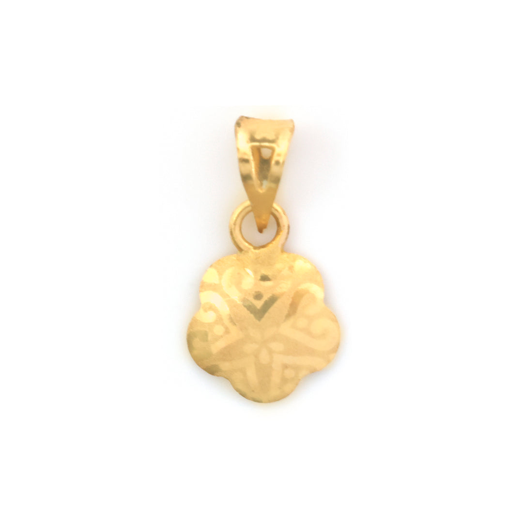 A small gold pendant with a floral or clover-like outline and engraved geometric patterns, shown on a plain white background.