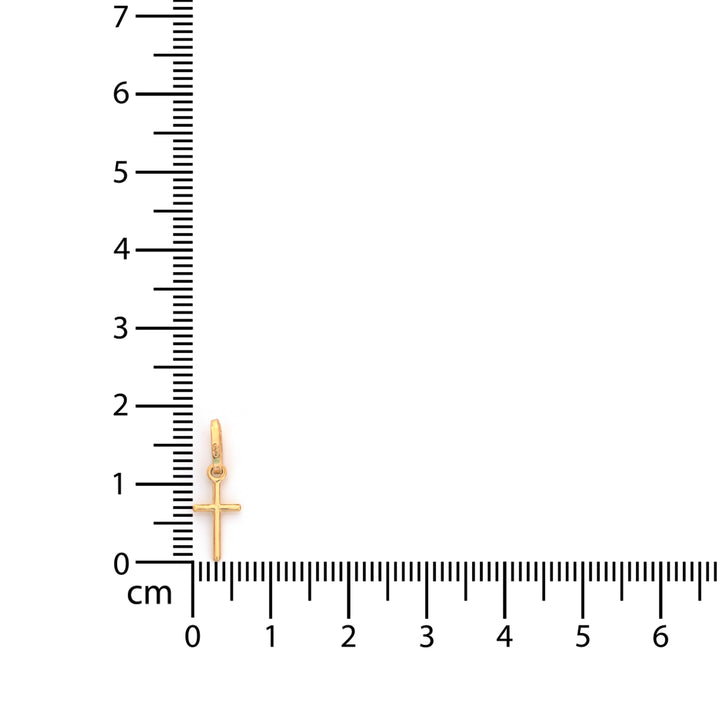 A small gold cross pendant displayed next to a centimeter ruler on a plain white background, showing its scale.