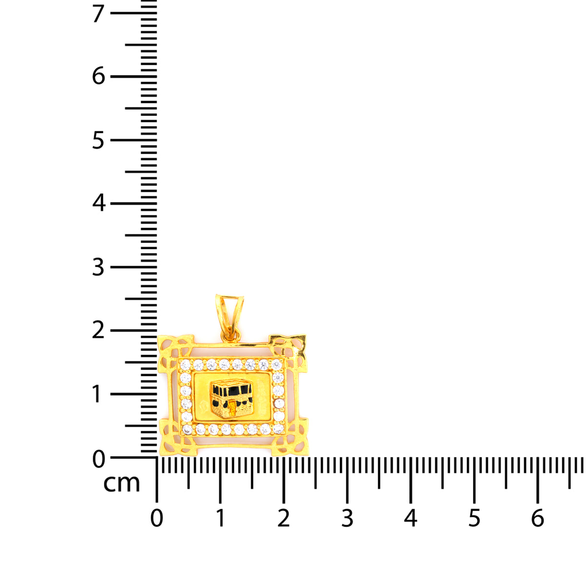 Gold pendant with embedded stones on a ruler for scale
