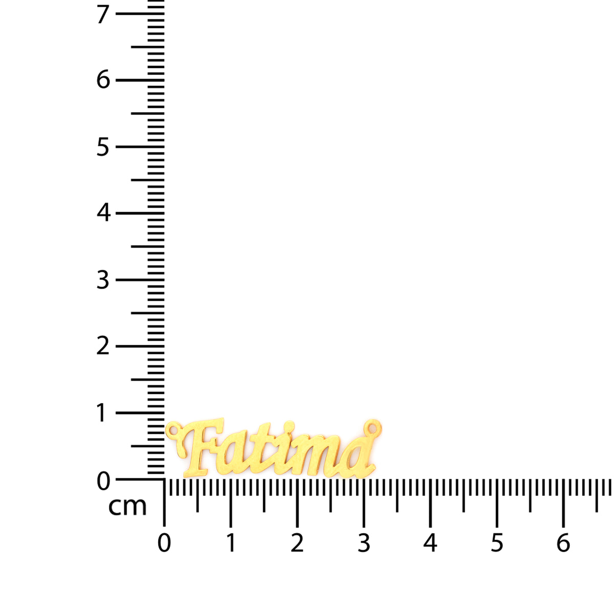 Gold name charm labeled 'Fatima' on a ruler for scale