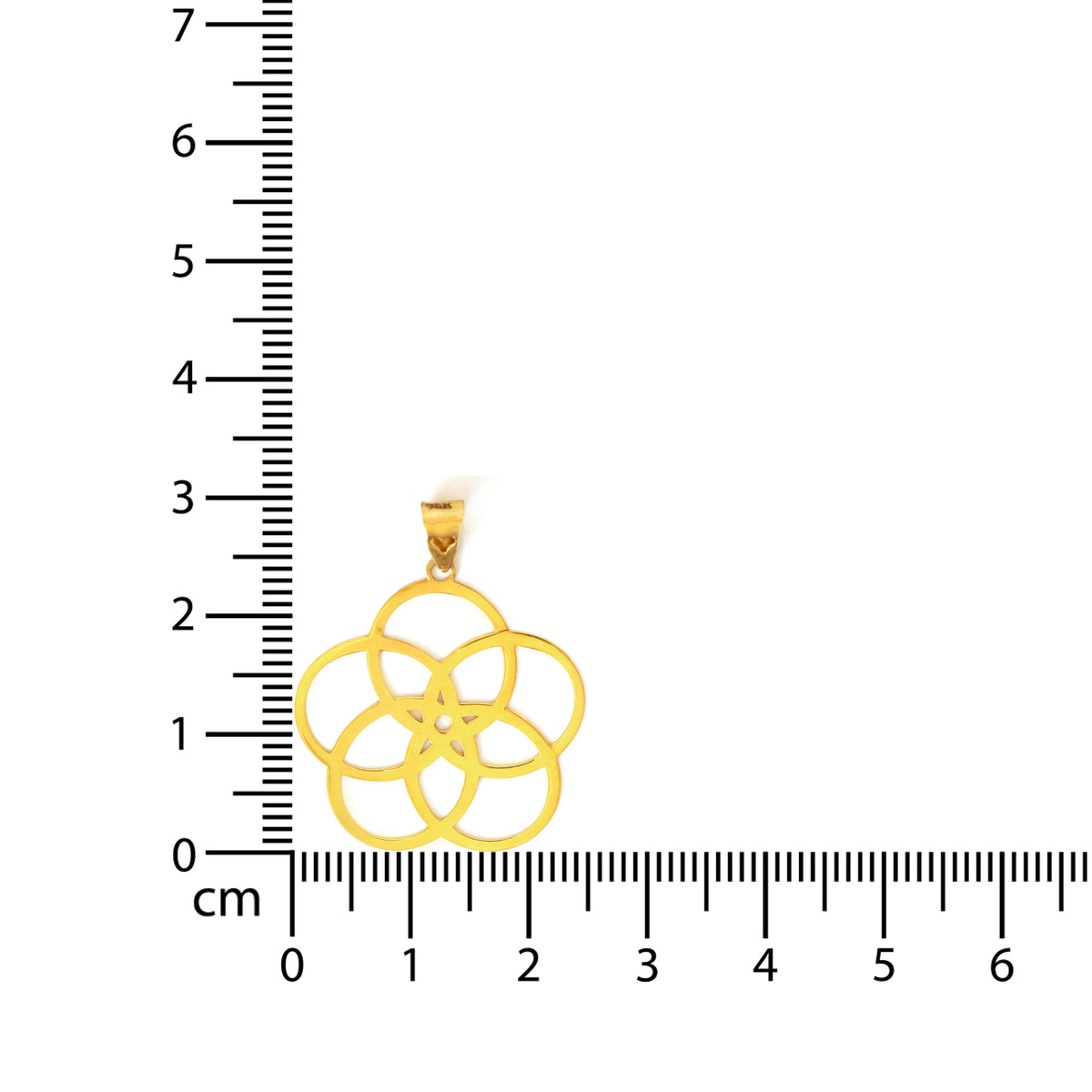 Gold pendant with a floral design on a white background, measured against a ruler.