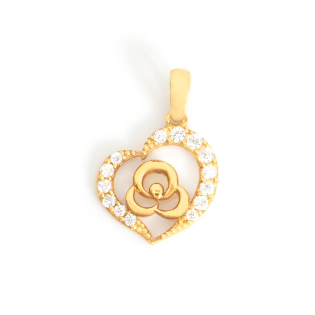 A gold heart-shaped pendant with a central flower motif, accented by small clear stones along the outer border, shown on a plain white background.