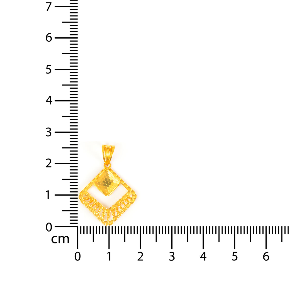 Gold pendant with a diamond cut design on a white background with a ruler for scale.