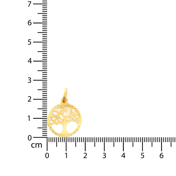 Gold pendant with tree of life design on a ruler for scale