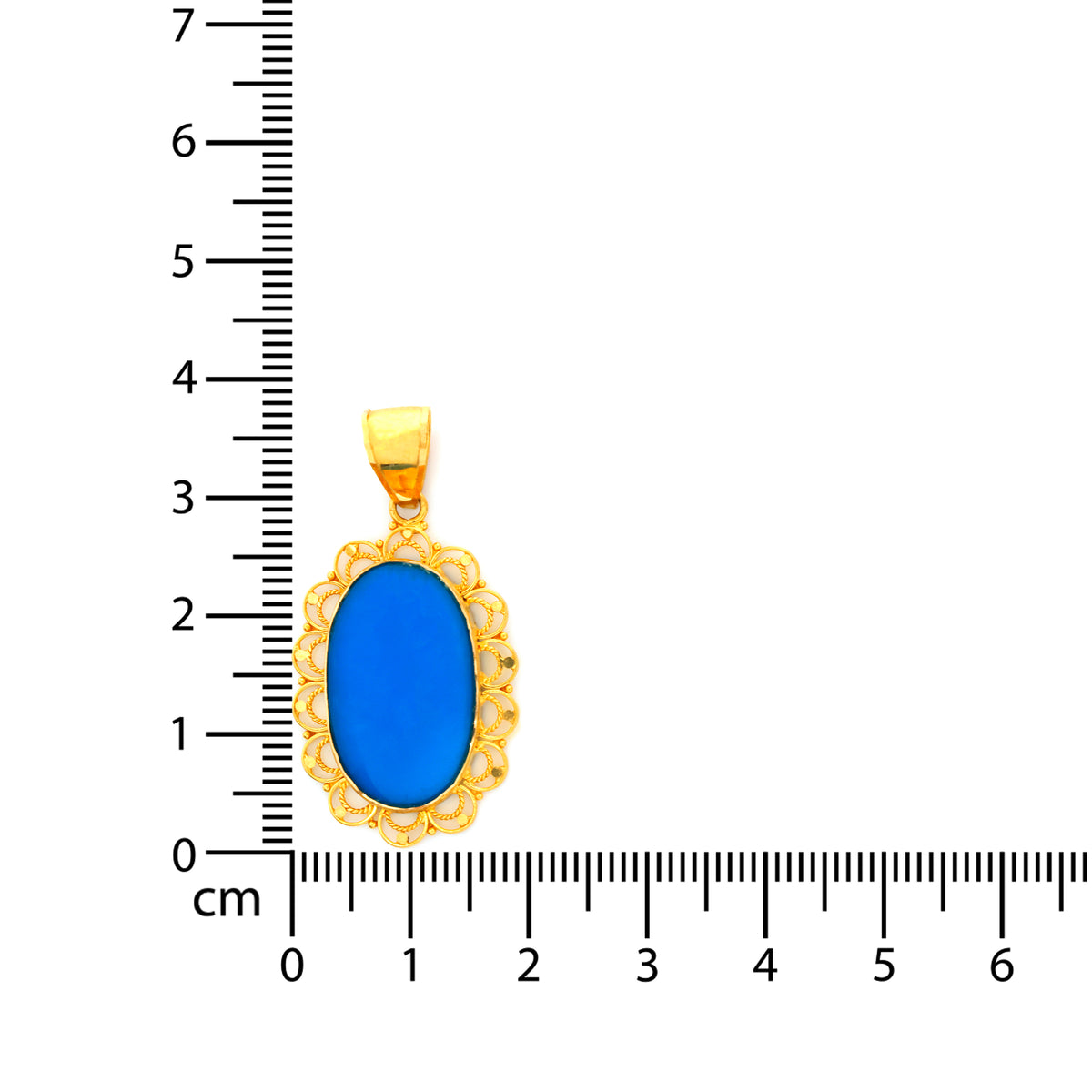 Gold pendant with blue stone next to a ruler for scale on a white background