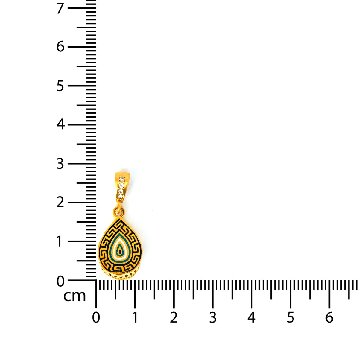 Gold pendant with intricate design on a white background with a ruler for scale.