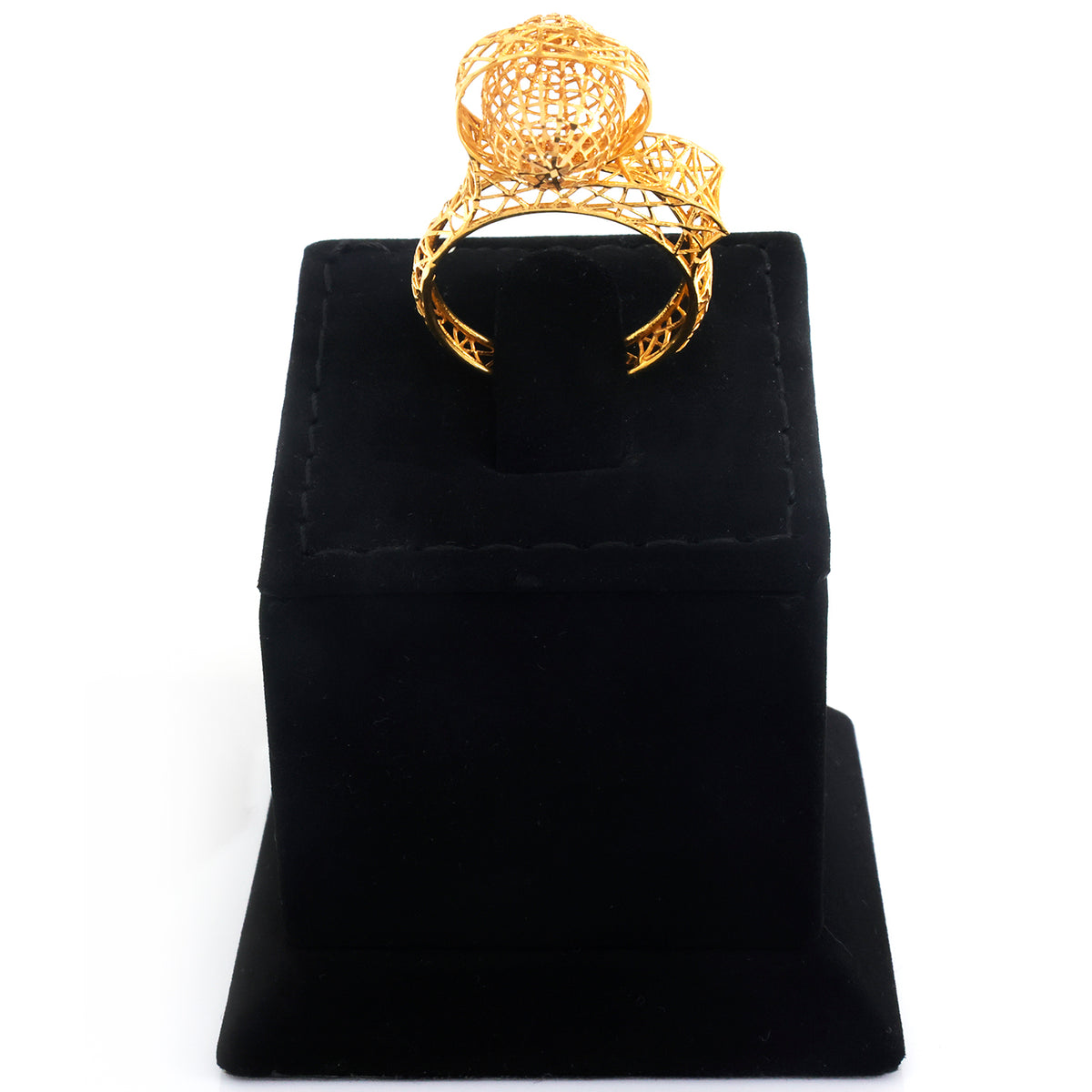 A gold filigree ring with a large, intricate spherical top, displayed on a black velvet jewelry stand against a white background.