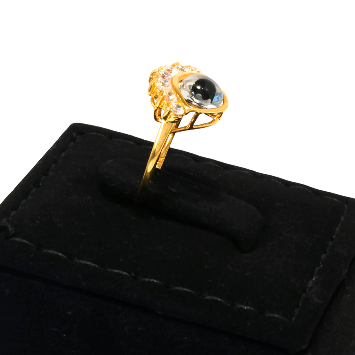 Gold ring with a central black gemstone on a black velvet stand
