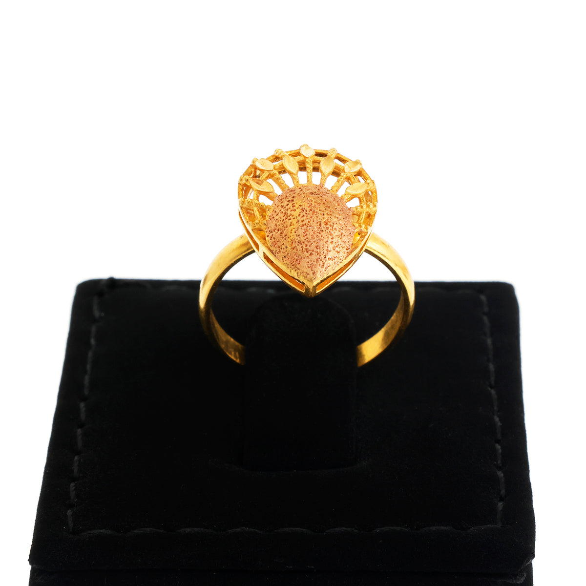 Gold heart-shaped ring on a black velvet stand with a white background