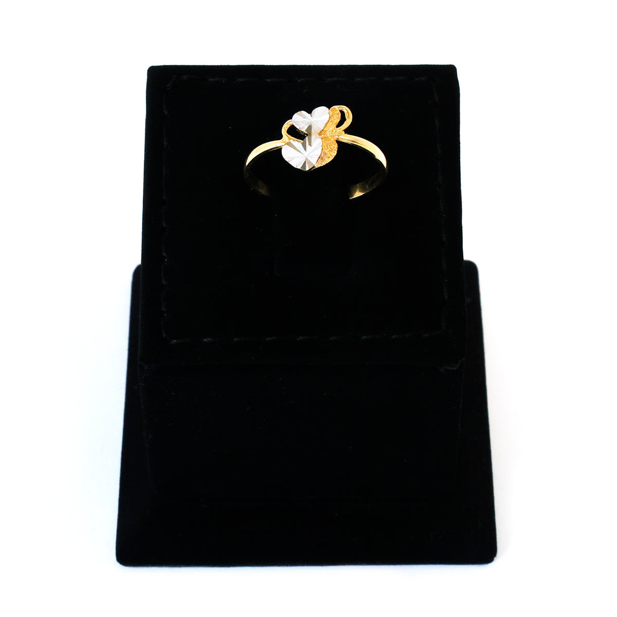 Gold ring with a heart design on a black velvet stand
