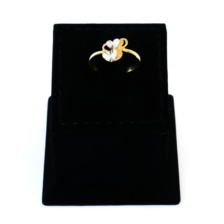 Gold ring with a heart design on a black velvet stand