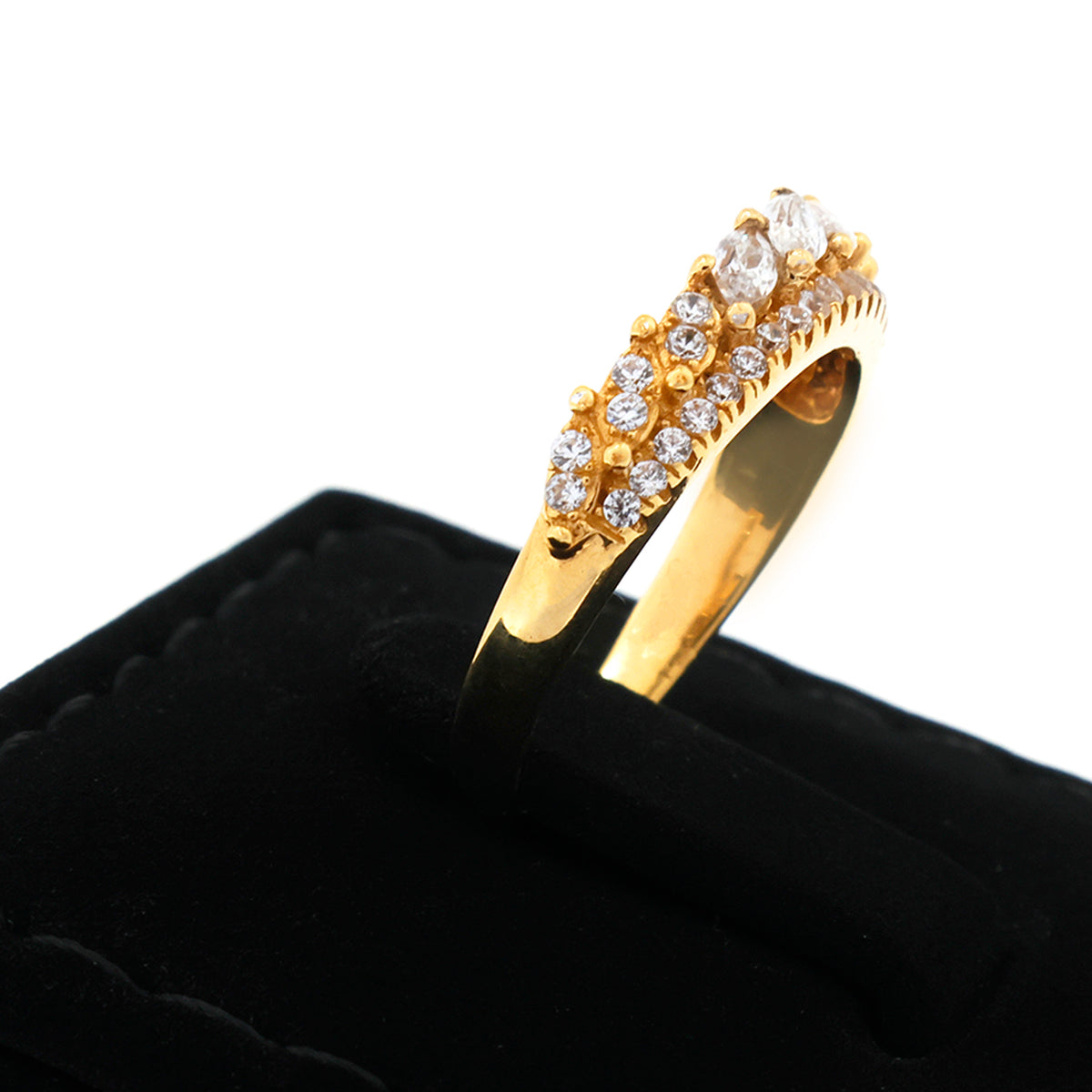 Gold ring with diamond accents on a black cushion against a white background