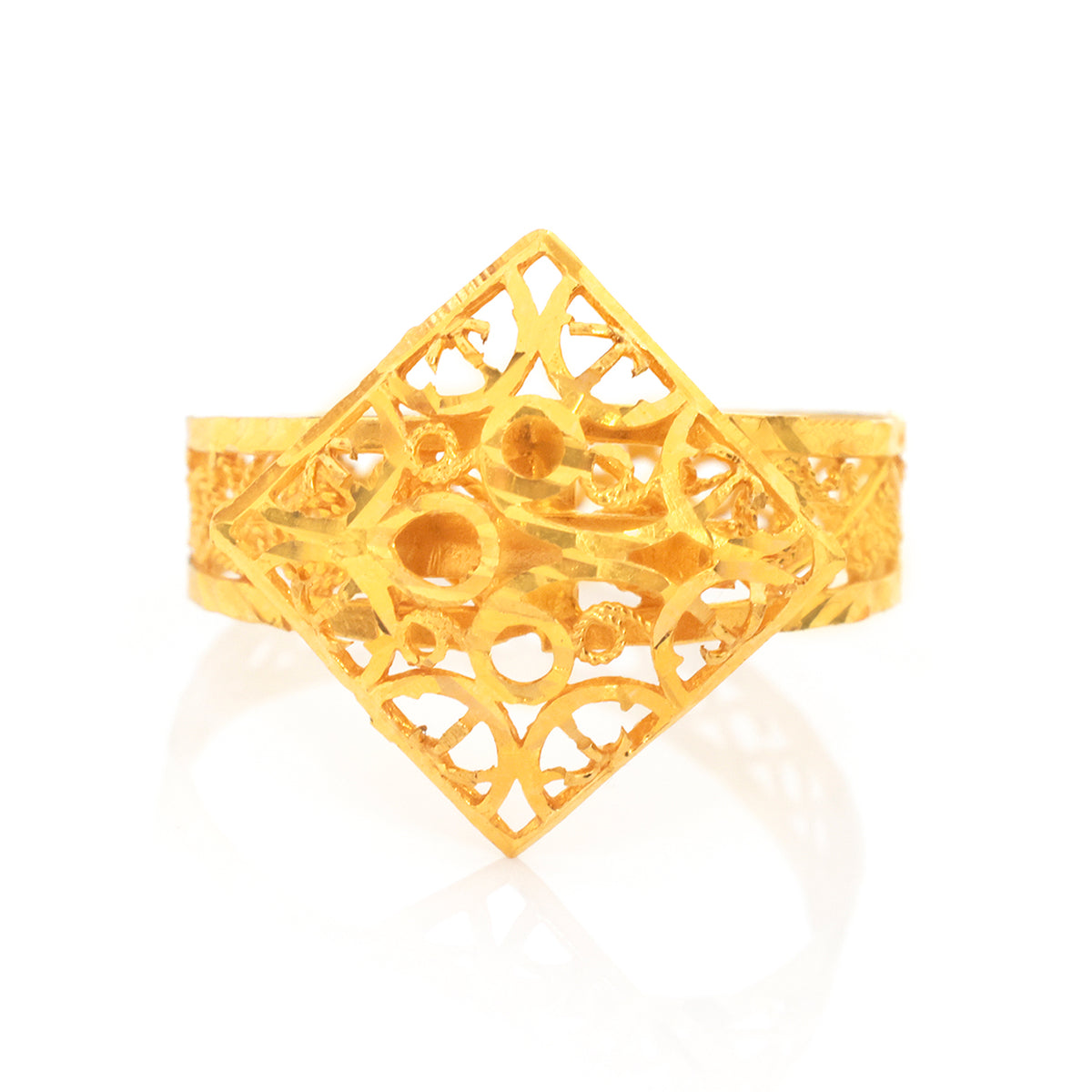A yellow gold filigree ring with a large diamond-shaped openwork top and patterned band, shown on a white background with a soft reflection.