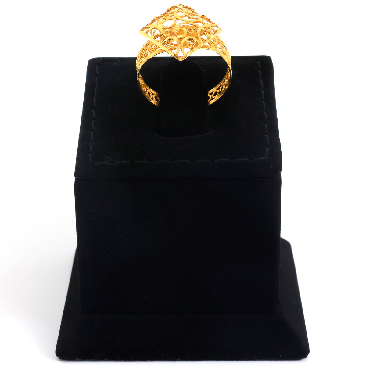 A gold ring with an intricate filigree and floral design, displayed on a black velvet jewelry stand against a white background.