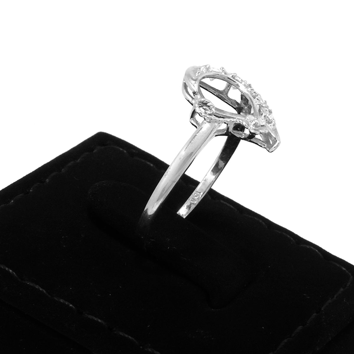 Silver ring with a clear gemstone on a black cushion