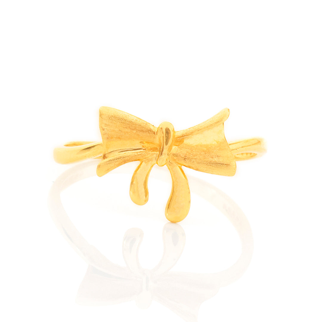 Gold bow-shaped ring on a white background
