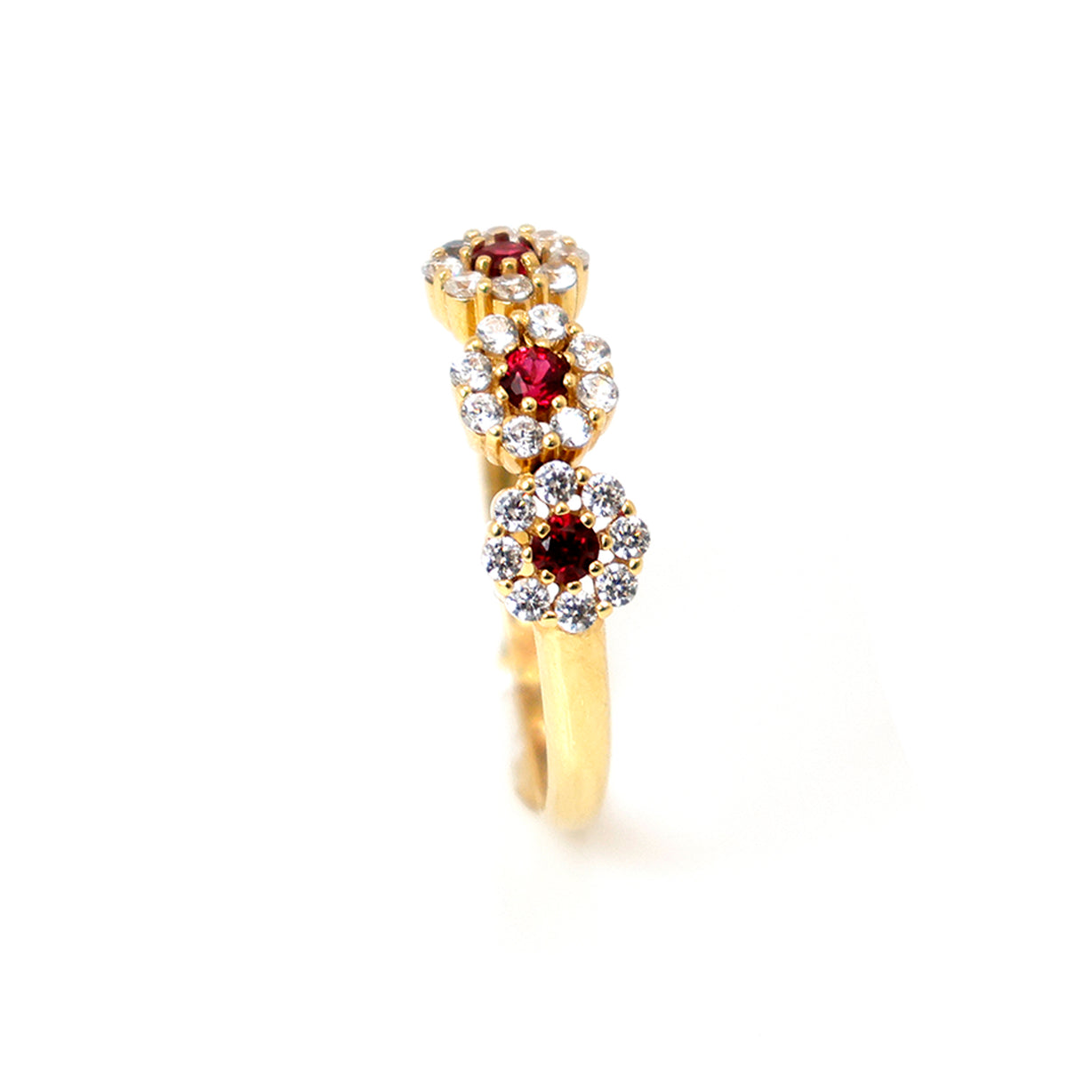 Gold ring with red and clear gemstones on a white background